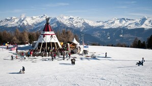 A snow-covered ski resort with a large gathering of people and a prominent tipi structure. - Pleasant Apartment With Balcony (Veysonnaz)