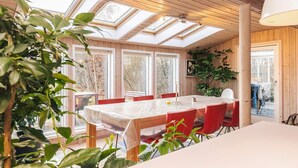 Un espace repas comprenant une table, des chaises et une grande fenêtre dotée de lucarnes.