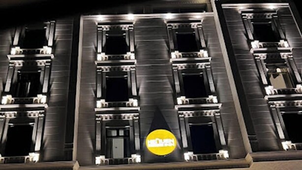 A hotel with a modern facade, large windows, and a prominent yellow sign. - Heaven inn 1 (Abha)