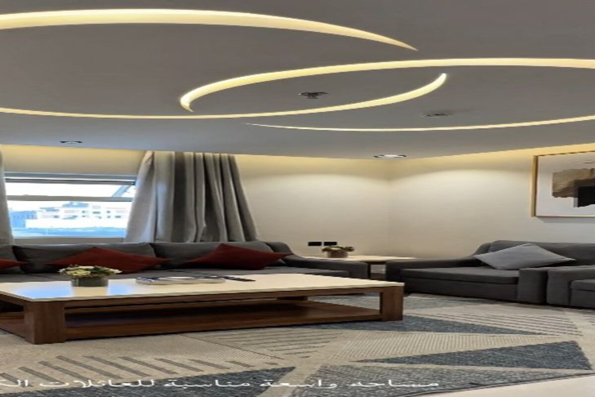 A modern living room with a sofa, coffee table, and a television.