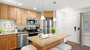 A modern kitchen with wooden cabinets, stainless steel appliances, and a granite countertop. - Red Pine N3 | Fireplace | Full Kitchen | Washer & Dryer | Patio | Pools & Hot Tub | Walk to Lifts (Park City)