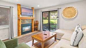 A living room with a fireplace, a television, a wooden coffee table, and a sofa. - Red Pine N3 | Fireplace | Full Kitchen | Washer & Dryer | Patio | Pools & Hot Tub | Walk to Lifts (Park City)