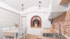 A compact kitchen with a brick archway, white cabinetry, and a wooden countertop. - Hidden Gem Holiday Home With Pool in Kastel Stafilic (Kastela)