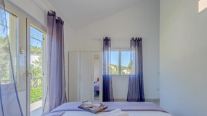 A bedroom with a bed, a window, and a door. - Seaside Getaway Holiday Home With Patio Slatine (Split)