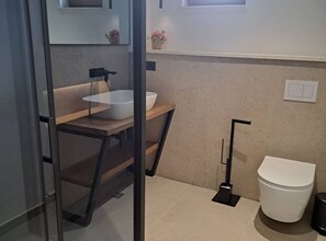 A modern bathroom with a glass partition, a white sink, a toilet, and a small window. - Tranquil Holiday Home With Pool, Garden, and Playground in a Peaceful Countryside Setting (Sinj)