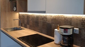 Una cucina moderna con piano cottura integrato, lavello e macchina da caffè.