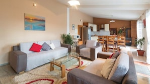 A modern living room with a sofa, armchairs, a glass coffee table, and a painting on the wall. - Mediterranean Stylish Villa With Pool in Kastel Stari (Kastela)