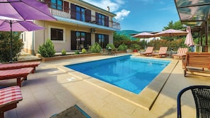 A swimming pool with lounge chairs and umbrellas, a two-story building with balconies, and a clear blue sky. - Mediterranean Stylish Villa With Pool in Kastel Stari (Kastela)