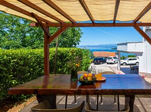 Una mesa al aire libre con vista al mar y coches aparcados.