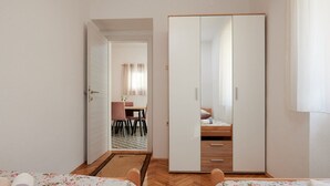 A room with two beds, a dining area, and a wardrobe. - Cozy Downtown Trogir Apartment With Balcony (Trogir)
