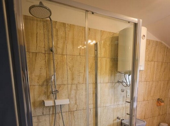 A modern bathroom with a glass shower enclosure, marble tiles, and a visible toilet. - Exclusive Elegant Villa With Pool in Kastel Novi (Kastela)