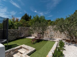 Enjoy a serene atmosphere in this outdoor space surrounded by lush greenery and trees.