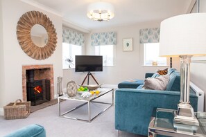 A living room with a fireplace, a television, a sofa, and a coffee table.
