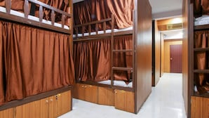 A room with bunk beds, wooden wardrobes, and a tiled floor. - Neon Nest Dormitory Suits (Mumbai)
