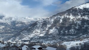 Eine Berglandschaft mit schneebedeckten Häusern und einer Kirche.