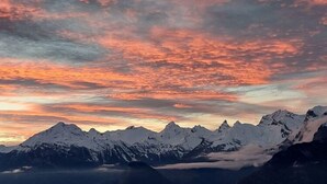 A mountain range with snow-capped peaks and a colorful sky. - Mystical Apartment With Mountain Views (Veysonnaz)