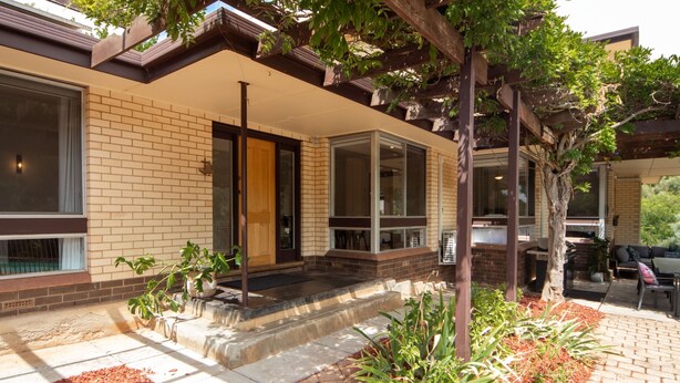 A modern house with a brick exterior, large windows, and a covered porch. - Sandy Pool Shack - Pet Friendly (Seacliff Park)