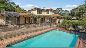 A two-story house with a swimming pool, solar panels, and a fenced patio area. - Sandy Pool Shack - Pet Friendly (Seacliff Park)