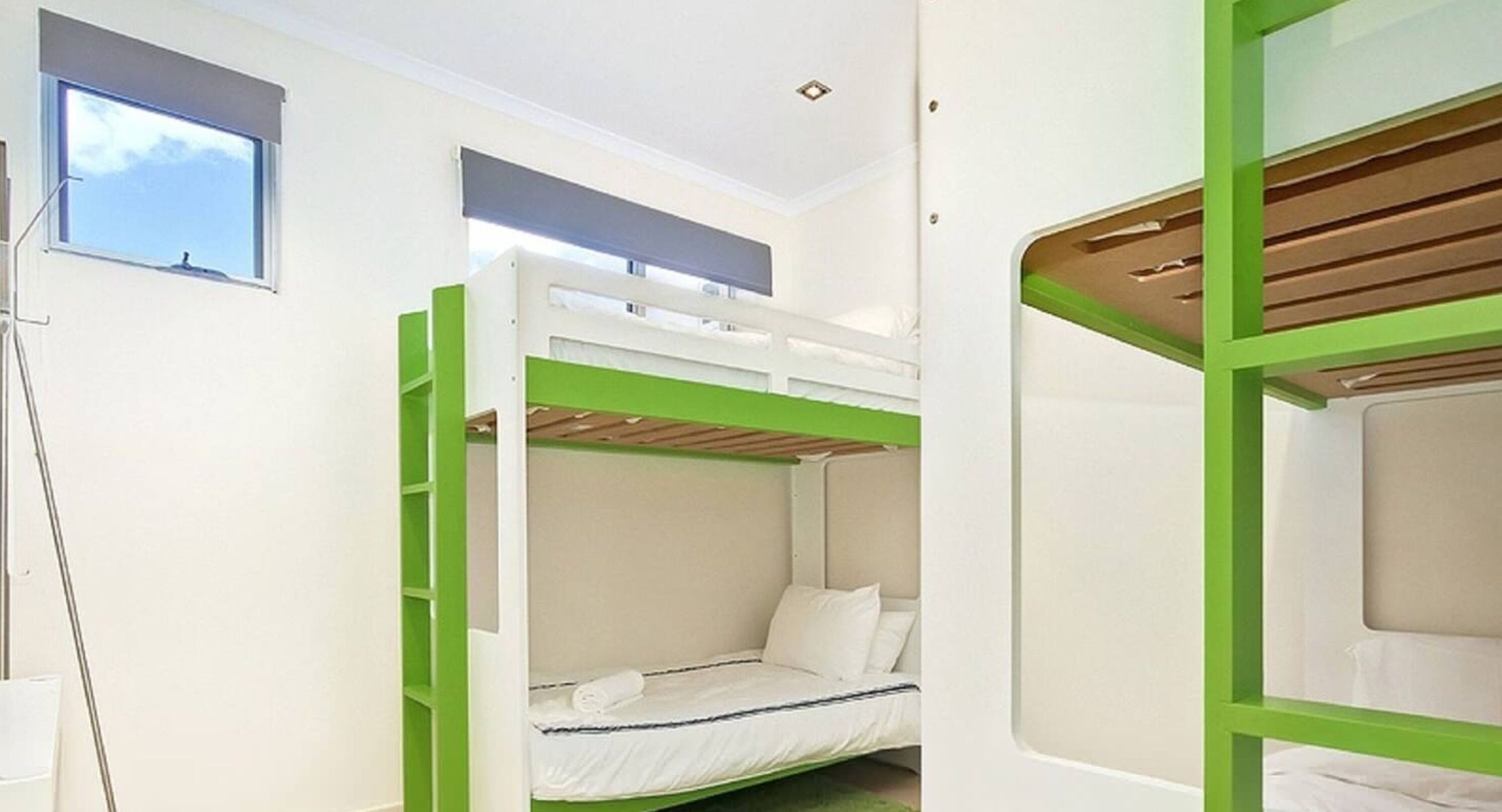 A bunk bed room with a window and a ladder.