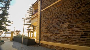 Un bâtiment en pierre doté d’un balcon, d’une allée pavée et offrant une vue sur la mer.