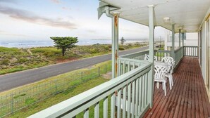 A covered porch with a view of the ocean and a road. - Tahren Beachfront Shack Wifi - Pet-friendly (Middleton)