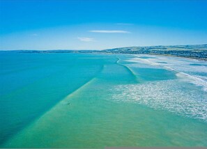 An aerial view of a coastal area with clear turquoise waters and a visible shoreline. - Tahren Beachfront Shack Wifi - Pet-friendly (Middleton)