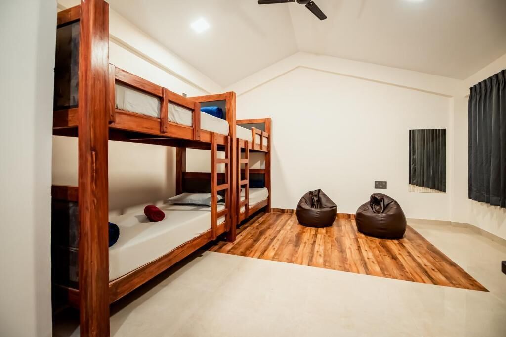 A room with bunk beds, a ceiling fan, and a bean bag chair.