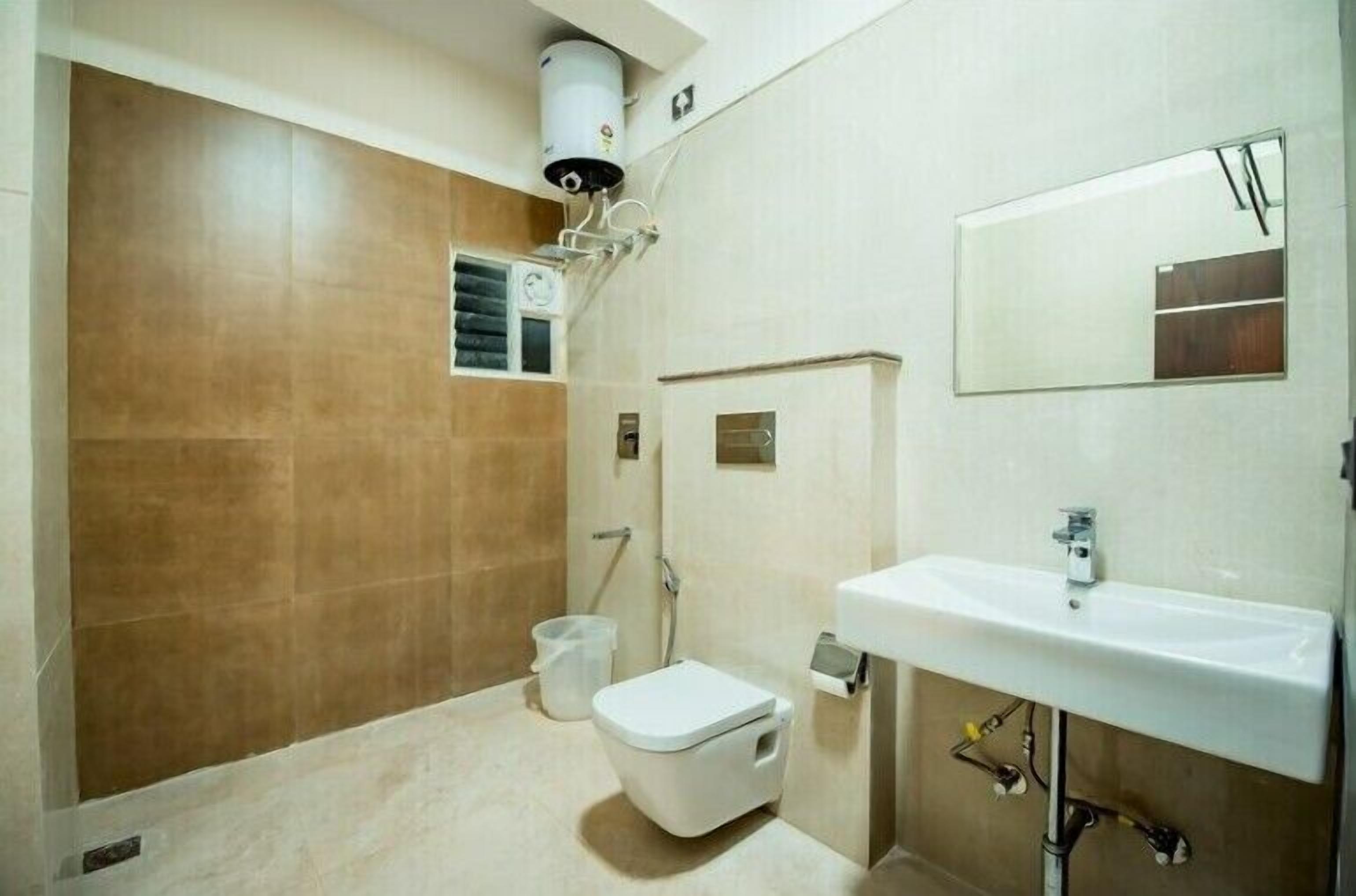 A bathroom with a toilet, sink, and mirror.