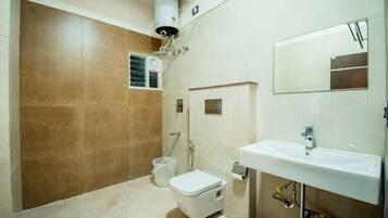 A bathroom with a toilet, sink, and mirror.