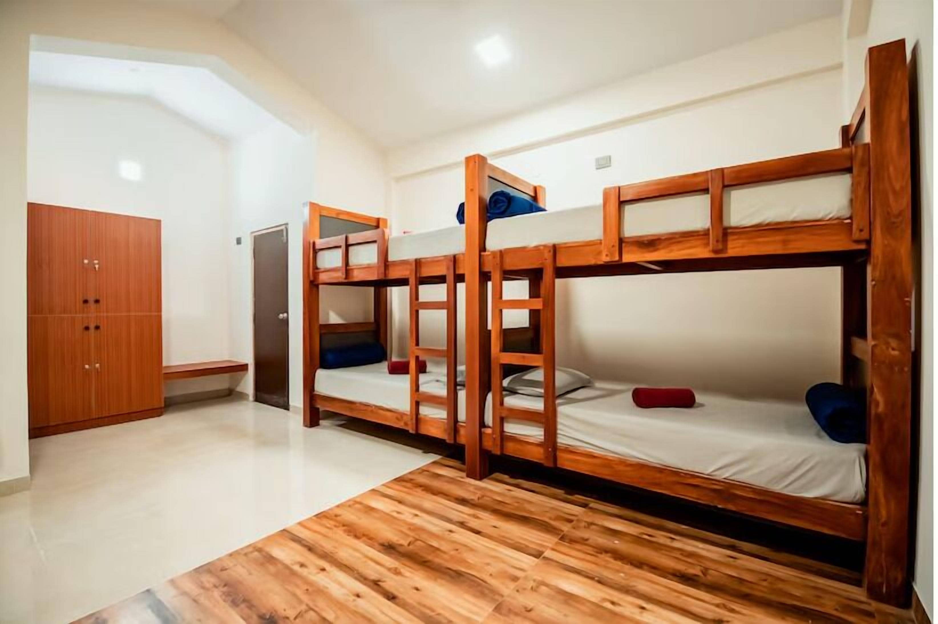 Ein Zimmer mit Etagenbetten, einem Holzschrank und einer Tür.