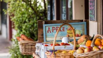 A fruit stand with a sign that reads "APPLE" and baskets of bread and fruit.
