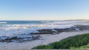 Une plage au rivage rocheux, avec des vagues.