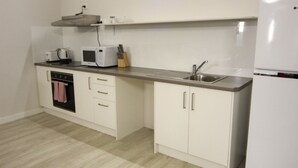 A compact kitchen with a microwave, toaster, and sink.