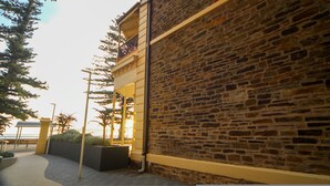 A stone building with a balcony and a paved walkway.