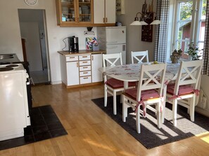 A compact kitchen with a dining area, featuring a refrigerator, stove, and a dining table with chairs. - 4 Person Holiday Home in Animskog (Ånimskog)