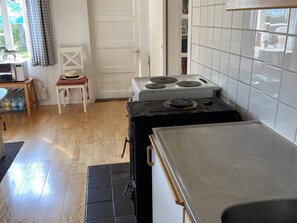 A kitchen with a stove, a sink, and a chair. - 4 Person Holiday Home in Animskog (Ånimskog)
