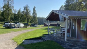 A campground with RVs, a covered picnic area, and a building with a sign. - 4 Person Holiday Home in Animskog (Ånimskog)
