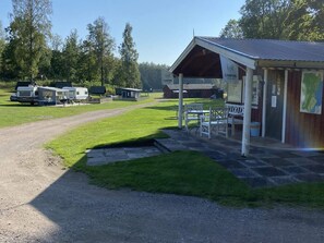 A campground with RVs, a covered picnic area, and a building with a sign. - 4 Person Holiday Home in Animskog (Ånimskog)