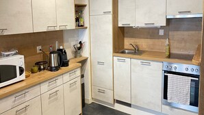 A compact kitchen with a microwave, coffee maker, and stove. - Ski Lift Apartment With Views (Veysonnaz)