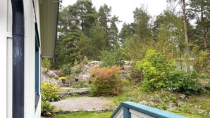 A residential property with a stone pathway leading to a wooden deck, surrounded by lush greenery and trees. - 4 Star Holiday Home in Amal (Åmål)