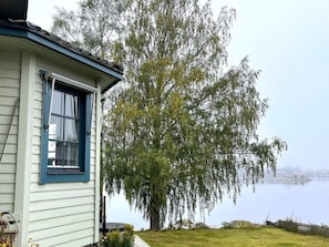 A house with a blue window and a large tree in front. - 4 Star Holiday Home in Amal (Åmål)