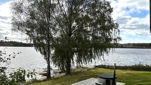 A lakeside property with a wooden deck, a sauna, and a view of the water. - 4 Star Holiday Home in Amal (Åmål)