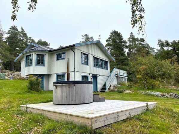 A two-story house with a deck and a staircase leading to a balcony. - 4 Star Holiday Home in Amal (Åmål)