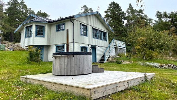A two-story house with a balcony and a wooden deck.