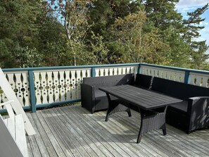 An outdoor deck with a table and two black wicker sofas. - 4 Star Holiday Home in Amal (Åmål)