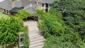 Una propiedad residencial con varias casas, un porche cubierto y abundante vegetación.