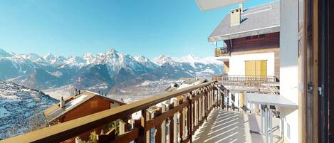 A balcony with a view of snow-covered mountains.