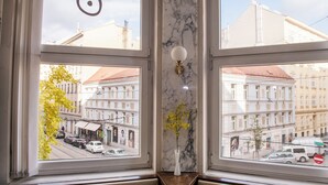 A window with a marble wall and a vase with yellow flowers. - Vienna Boutique - Premium Hostel (Vienna)