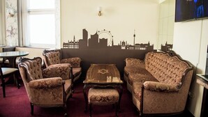 A room with a city skyline mural, a round table, and four upholstered chairs. - Vienna Boutique - Premium Hostel (Vienna)