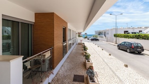 Un bâtiment moderne doté d’un balcon donnant sur une rue et sur un plan d’eau.